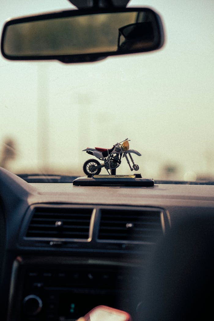 Motorcycle figurine decor on car dashboard, artistic shot.