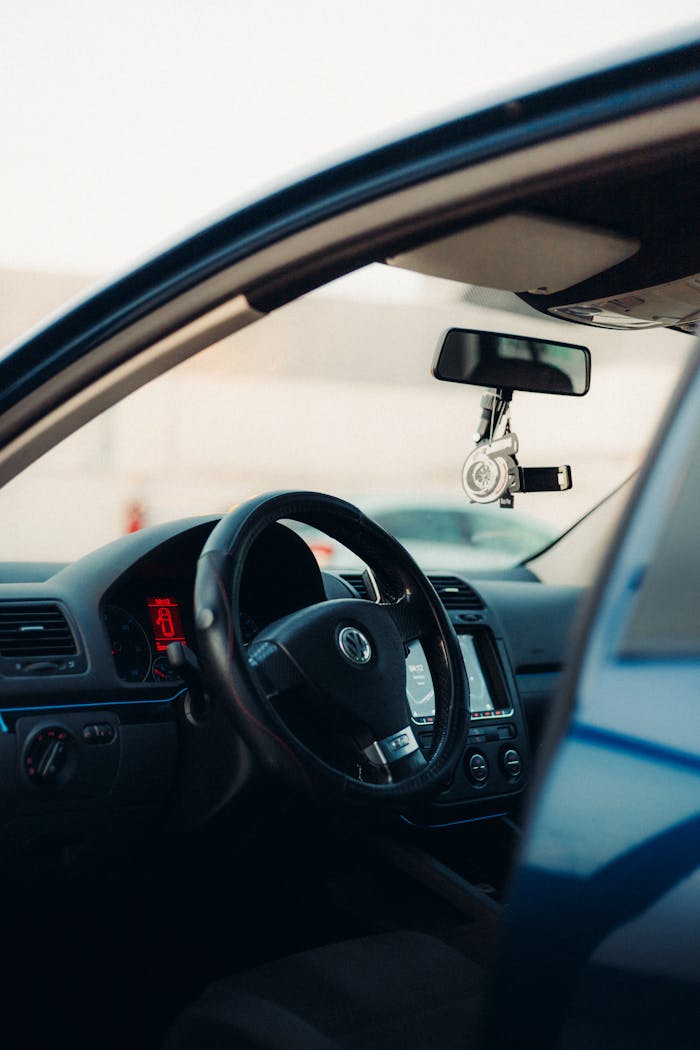 View of car interior focusing on steering wheel and dashboard.