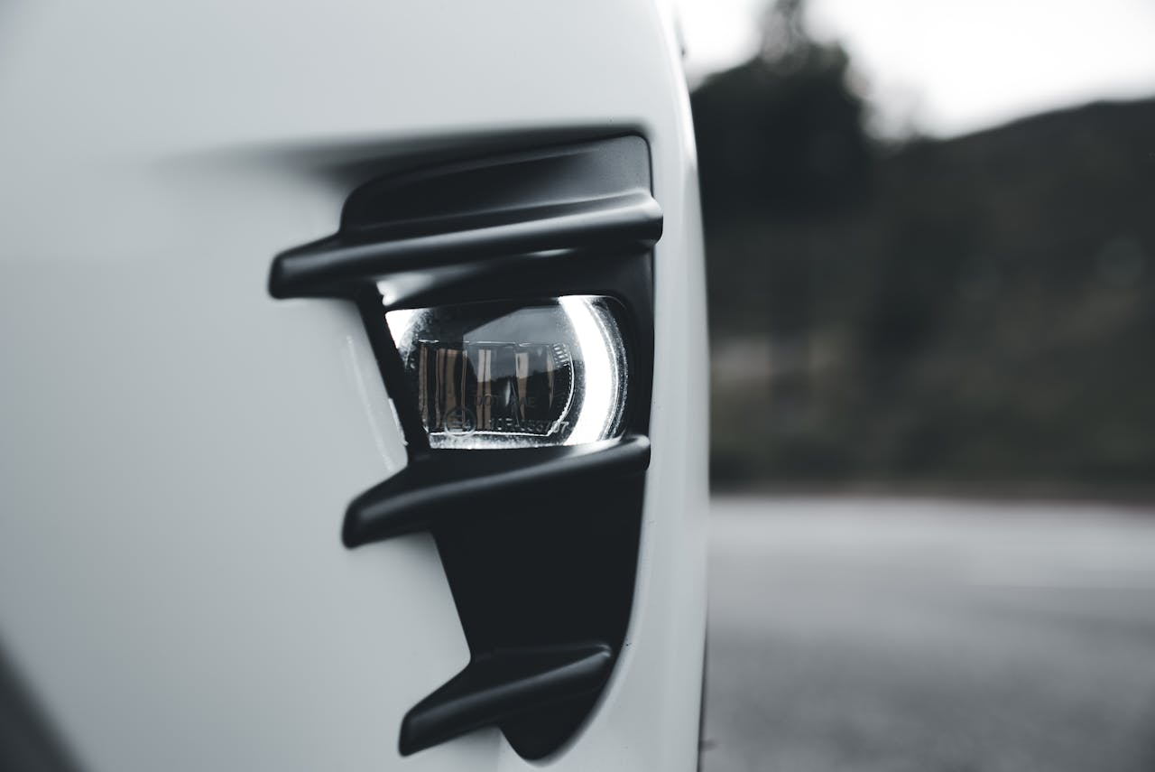 Detailed close-up of a sleek car headlight featuring modern design elements with ambient lighting.