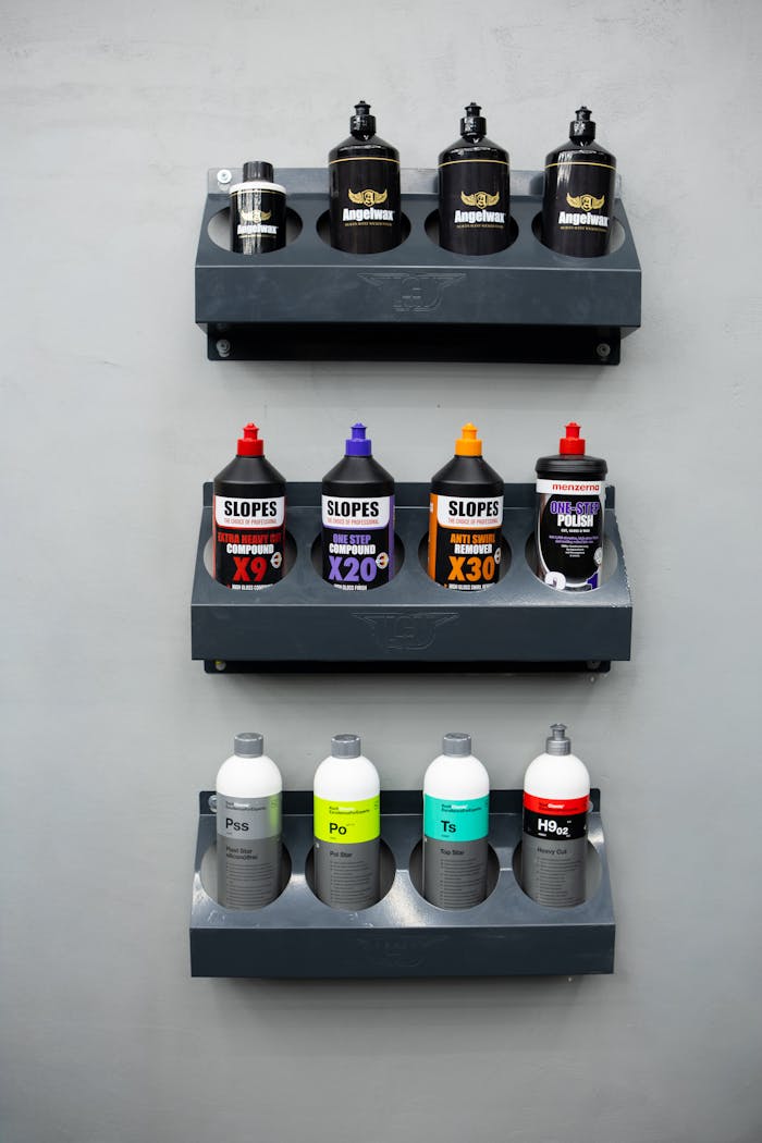 Neatly organized shelves with various car cleaning and polishing products in vibrant bottles.